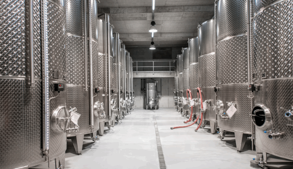 Stainless steel fermentation tanks aligned in a clean brewery facility featuring advanced brewery refrigeration systems.